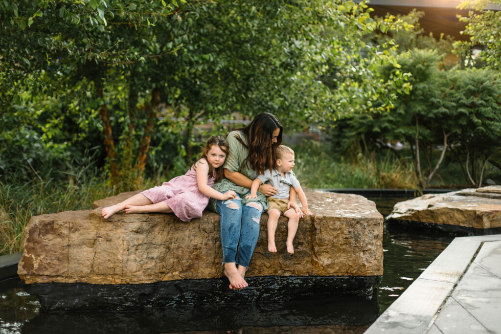 mom plays at the splash pad with her kids