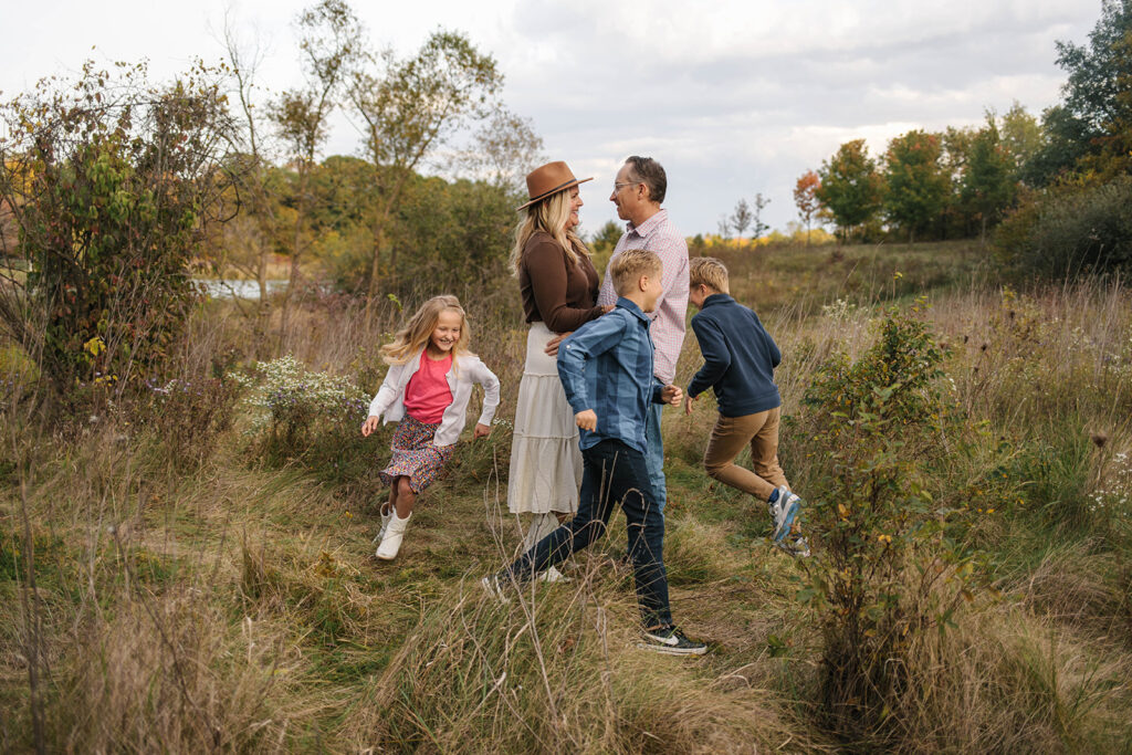 kids running around mom and dad hugging in Fort Wayne field